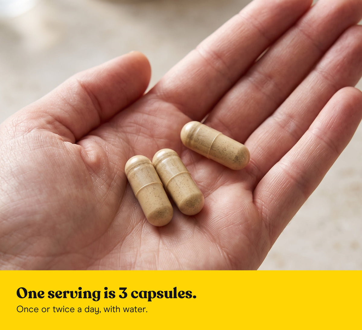 Three Lion's Mane extract capsules in an open hand: one serving is 3 capsules, once or twice a day, with water