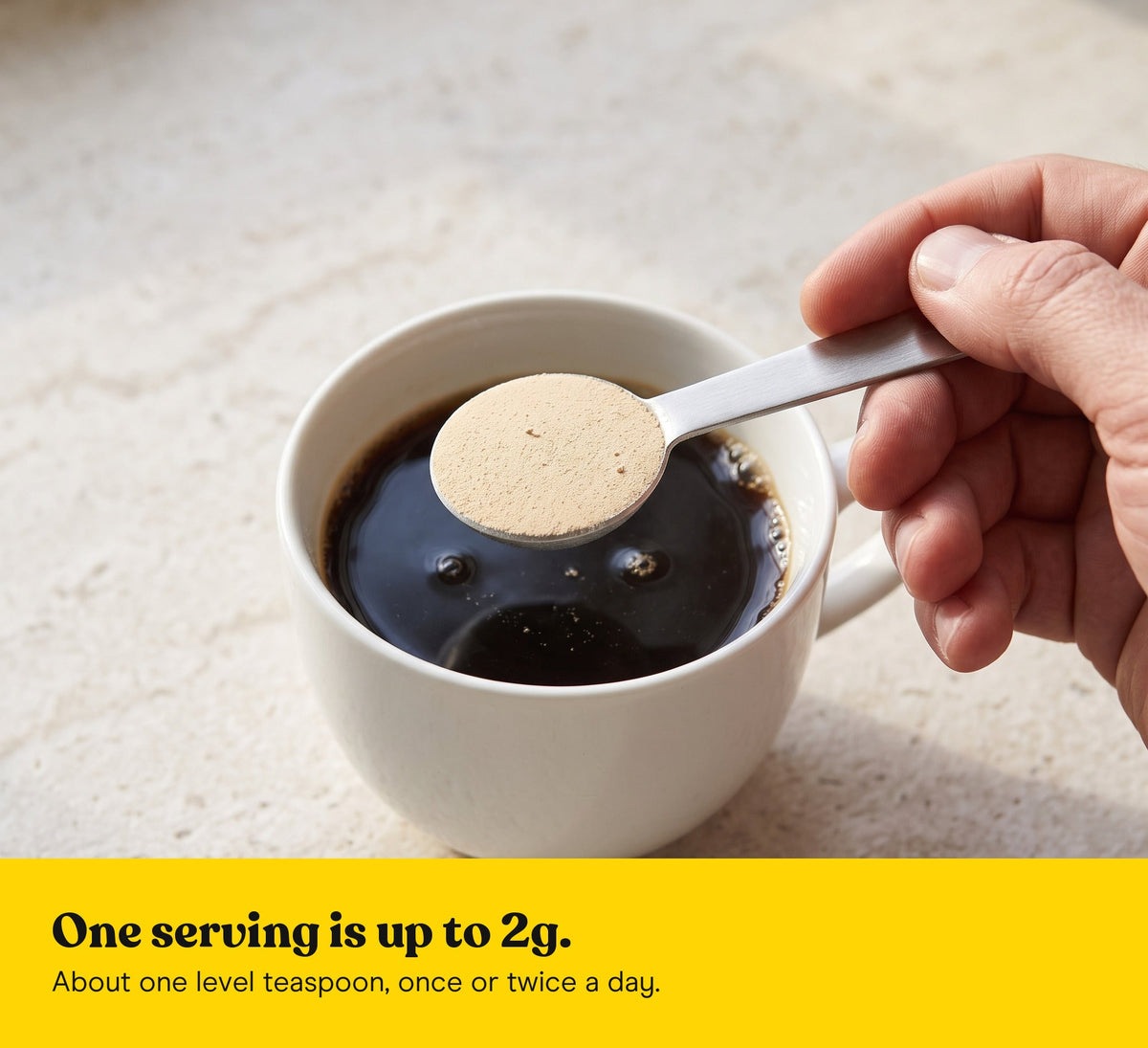 A level teaspoon of Lion's Mane extract powder held over a cup of coffee: one serving is up to 2g, once or twice a day