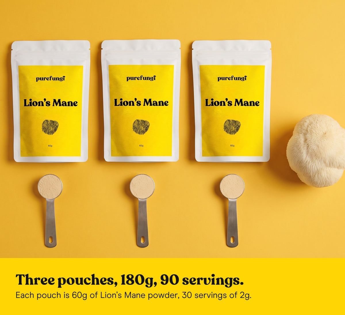 Three Pure Fungi Lion's Mane powder pouches lying flat with three measuring spoons of powder and a Lion's Mane mushroom on a yellow backdrop